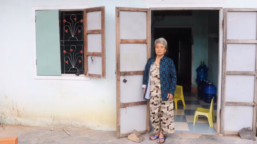 Bà Nguyễn Thị Xuân Khanh bên ngôi nhà nhỏ của mình. Ảnh: Ngọc Minh
