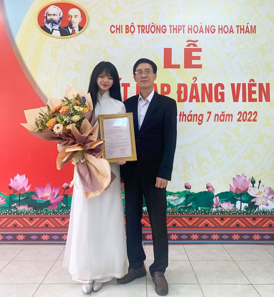  Thầy Nguyễn Văn Tàu-Bí thư chi bộ, Hiệu trưởng Trường THPT Hoàng Hoa Thám tặng hoa chúc mừng đảng viên trẻ Nguyễn Thị Minh Khánh. Ảnh: Thủy Bình