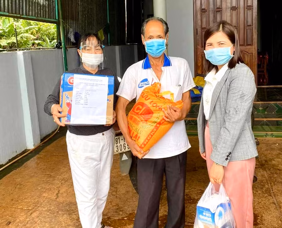 Chị Võ Thị Ánh Nguyệt (người đứng bìa trái)-Trưởng Ban công tác Mặt trận thôn 5 (phường Thắng Lợi, TP. Pleiku) tặng quà cho người dân trong thời điểm địa bàn diễn ra dịch Covid-19. Ảnh: Minh Nguyễn