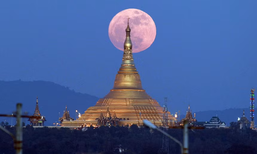  Siêu trăng mọc lên từ sau chùa Uppatasanti ở thủ đô Naypyidaw, Myanmar. Mặt Trăng lớn nhất và sáng nhất trong năm nay đã thắp sáng bầu trời vào tối 3-12 khi nó ở điểm gần nhất trong quỹ đạo quanh Trái Đất. Ảnh: AP.