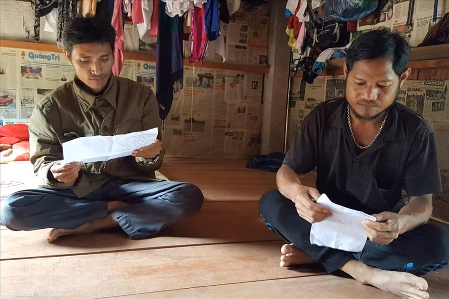 Ông Hồ Văn Liên (bìa phải ảnh) và ông Hồ Văn Việt (thôn Vực Leng) viết đơn trình báo với cơ quan chức năng việc nộp tiền cho cán bộ Dũng.