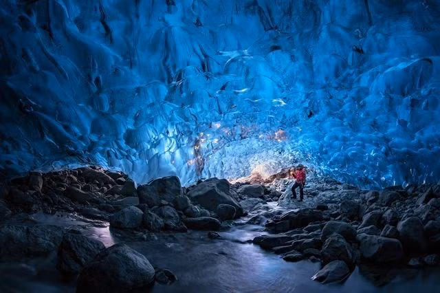 Một du khách đứng ở hang động bên trong dòng sông băng Vatnajokull, Iceland. (Nguồn: National Geographic)