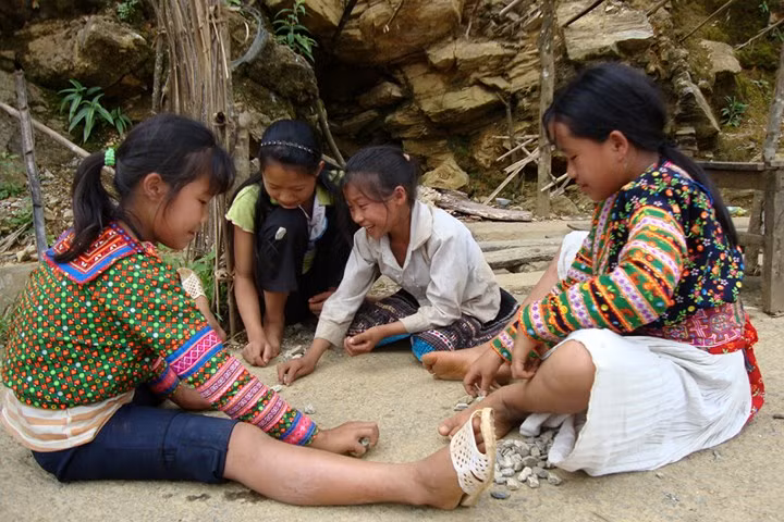  Còn trẻ em dân tộc Mông ở vùng cao huyện Phong Thổ lại tự chơi bên vệ đường, với bụi đất, đá sỏi