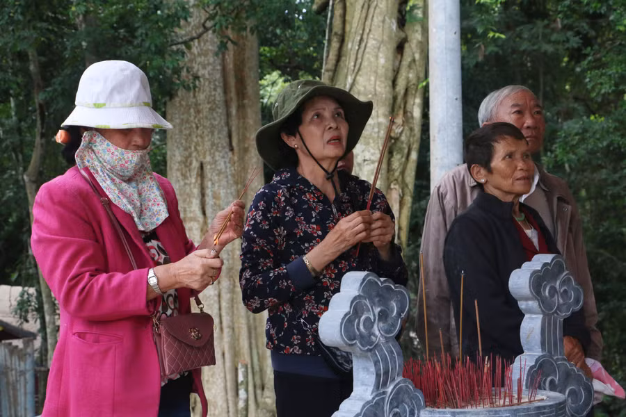 Bà Bền (ở giữa) đang thắp hương tưởng nhớ về những người anh, những đồng chí, đồng đội của mình đã nằm xuống nơi đây trong những năm chiến đấu ác liệt. Ảnh: Q.T