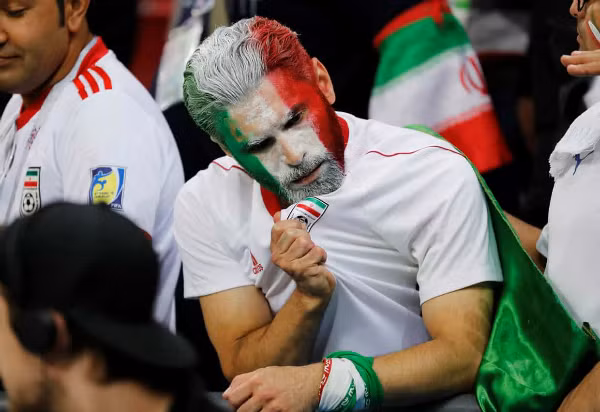 CĐV Iran gặm nhấm nỗi buồn sau trận, nhưng tự hào về đội bóng. Ảnh: Reuters.