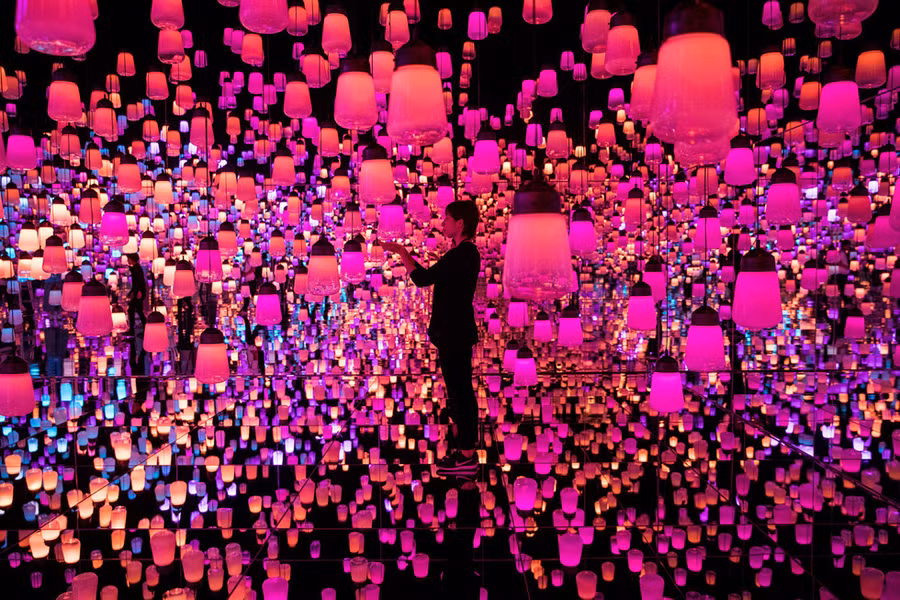  Một nữ du khách chạm tay vào chiếc đèn lồng tại một bảo tàng có tên Mori Building Digital Art Museum ở Tokyo của Nhật Bản - Ảnh: AFP