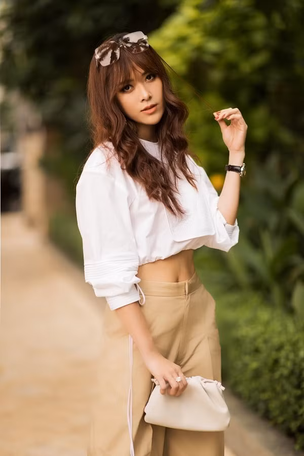 Bên cạnh đó, cách phối phụ kiện của người đẹp sinh năm 1993 cũng được đánh giá cao. Chân dài kết hợp với túi xách cầm tay đơn giản màu trắng, kính mát cùng hoa tai bản to giúp gây ấn tượng với người đối diện.