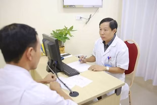 Phó giáo sư Nguyễn Quang khám cho một bệnh nhân. (Ảnh: PV/Vietnam+)