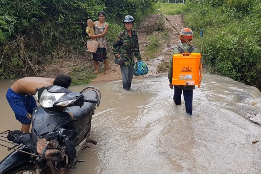 Người đàn ông mang bình bơm vừa phun xong thuốc diệt cỏ ở rẫy phía trên con suối. Còn gia đình anh Nguyên tắm rửa, múc nước đục ngàu ở con suối về sử dụng.