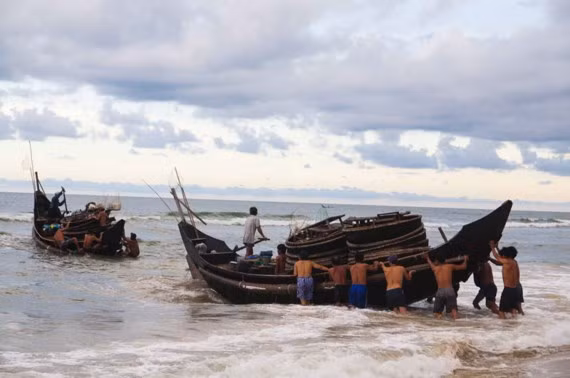Ngư dân đẩy thuyền ra khơi sau cơn bão vừa tan.