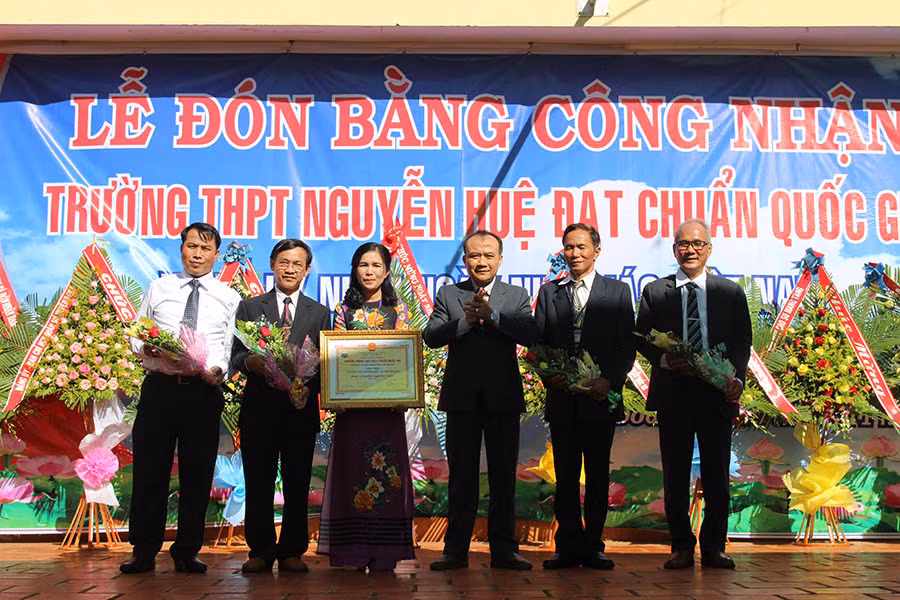  Ông Huỳnh Minh Thuận-Giám đốc Sở Giáo dục-Đào tạo trao Bằng công nhận trường đạt chuẩn quốc gia cho Ban Giám hiệu Trường THPT Nguyễn Huệ. Ảnh: Nguyễn Giang