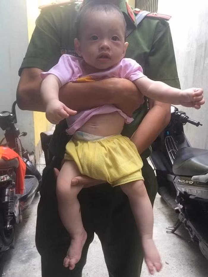 Cháu bé ngộ nghĩnh được phát hiện ở vỉa hè Quy Nhơn mặc quần vàng, áo hồng.