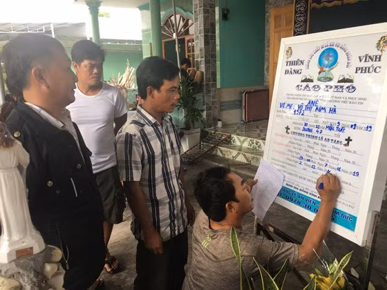 Người dân chòm xóm chuẩn bị tang lễ cho gia đình nạn nhân