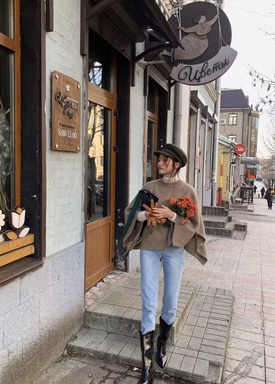 Áo len dáng cape được phối cùng jeans cổ điển, bốt và mũ baker boy giúp set đồ street style của các nàng trở nên bắt mắt hơn