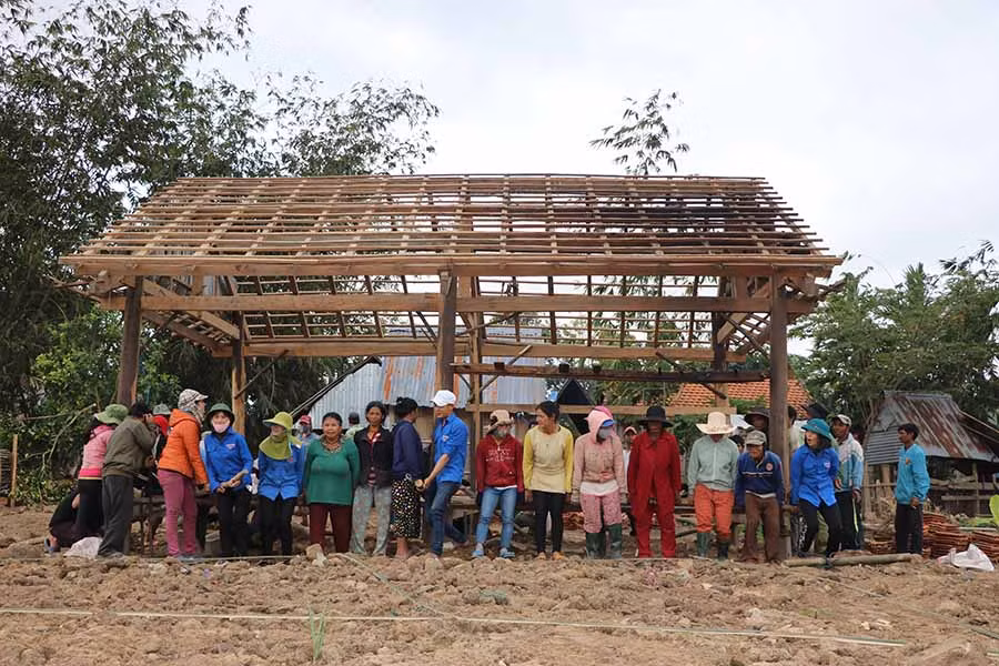 Ngôi nhà sàn năng hàng tấn được người dân dùng chính sức lực của mình để di dời về vị trí mới. Ảnh: Ngọc Minh