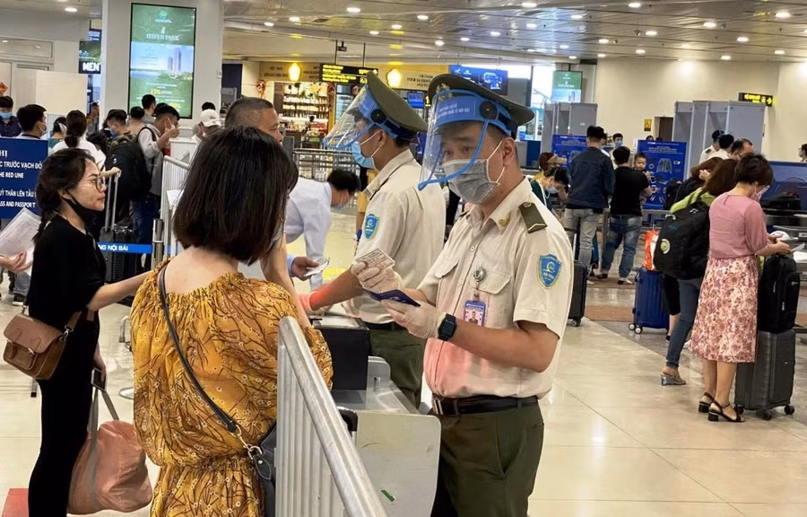 Lưc lượng an ninh hàng không tại sân bay Nội Bài kiểm soát thông tin hàng khách trước khi vào khu vực soi chiếu. (Ảnh: CTV/Vietnam+)