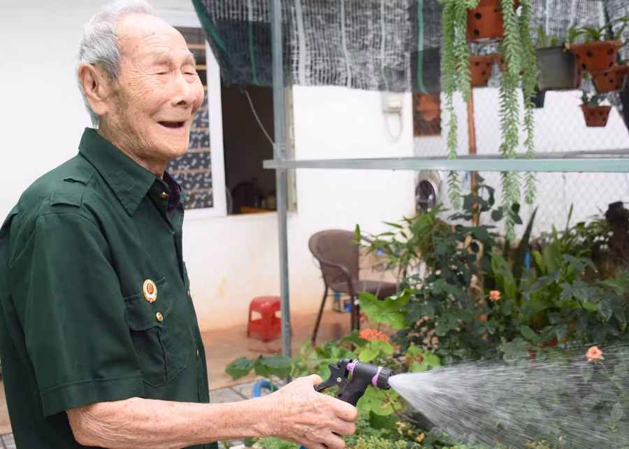 Niềm vui mỗi sáng của ông Trần Đức Tấn là chăm cây, tưới hoa. Ảnh: Phương Duyên