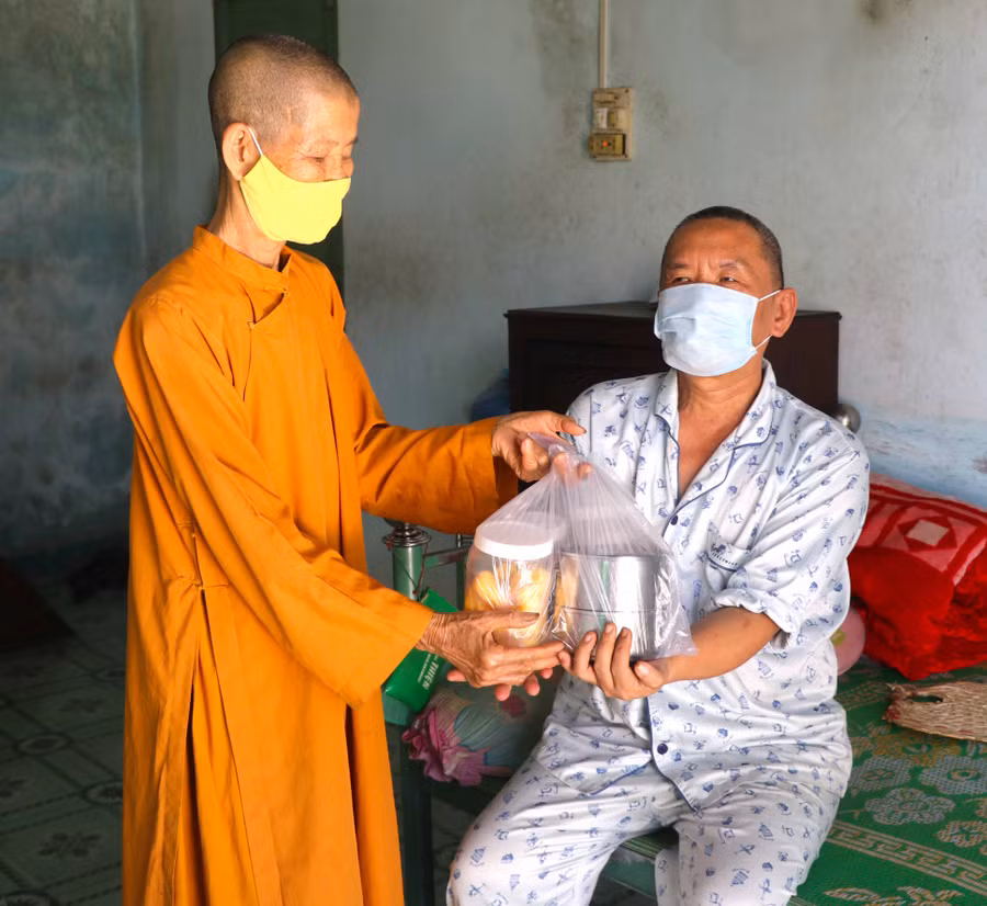 Không chỉ được hỗ trợ xây nhà, hàng ngày, ông Phạm Minh Đăng (bìa phải_ tổ 3, phường Tây Sơn, thị xã An Khê) được tịnh xá Ngọc Trung cưu mang. Ảnh Ngọc Minh