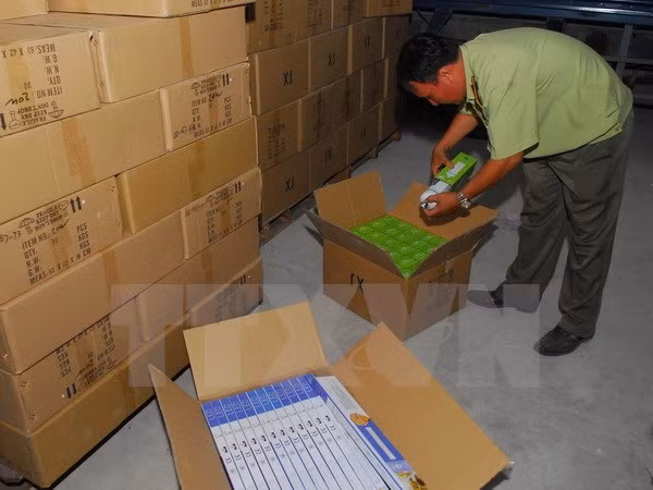  Lực lượng chức năng kiểm tra, thống kê số lượng hàng không hoá đơn, chứng từ. (Ảnh: Mạnh Linh/TTXVN)