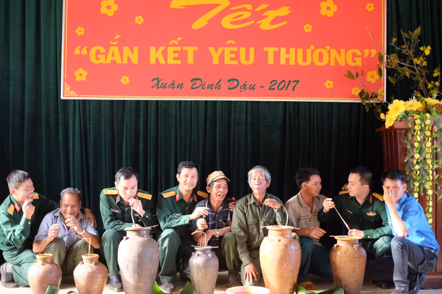 Bộ đội và dân làng cùng uống rượu cần. Ảnh: N.D Ảnh: N.D
