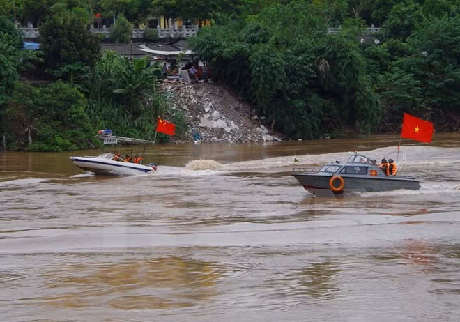 Lực lượng biên phòng hai bên tuần tra chung trên sông hồng. (Ảnh: Hồng Ninh/TTXVN)