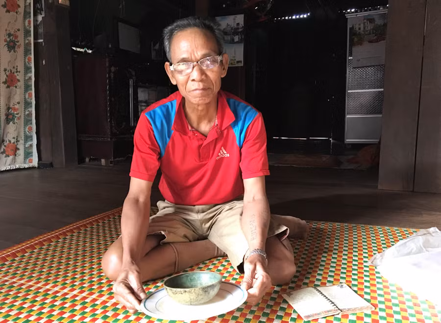 Ông Măng cùng bộ đồ dùng để đựng nước trong các dịp cúng lễ của “Vua nước” . Ảnh: P.L