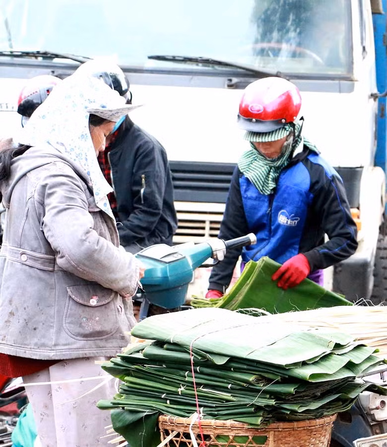 Tấp nập người mua, kẻ bán lá dong, chuối, dây lạt trong những ngày cận Tết. Ảnh: Q.T