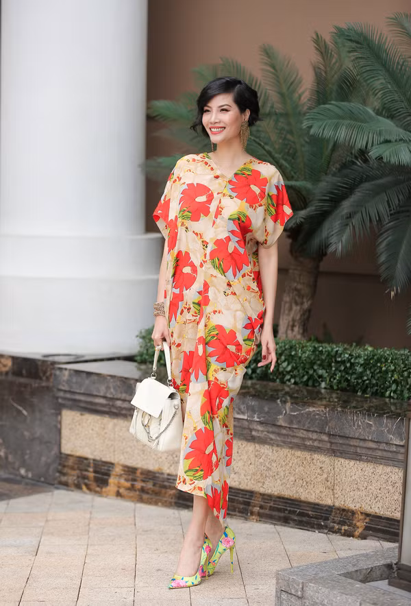 Cựu người mẫu Vũ Cẩm Nhung giúp mình thêm nổi bật khi kết hợp váy và giày cùng mang họa tiết hoa, xách túi nhấn nhá kim loại cá tính.