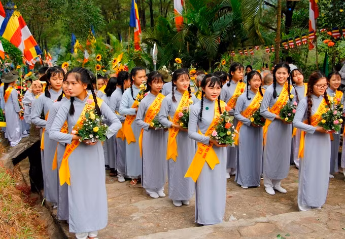 Đoàn nữ phật tử trong trang phục áo dài lam mang theo hoa dâng lên Quán Thế Âm Bồ Tát.