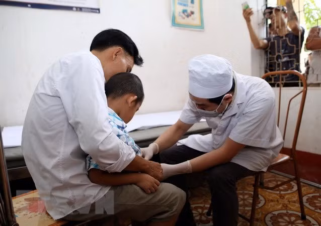  Bác sĩ Bệnh viện Da liễu Trung ương khám cho trẻ nhỏ mắc bệnh sùi mào gà do trước đây điều trị chít hẹp bao quy đầu tại cơ sở khám, chữa bệnh của bà Hoàng Thị Hiền. (Ảnh: Phạm Kiên/TTXVN)