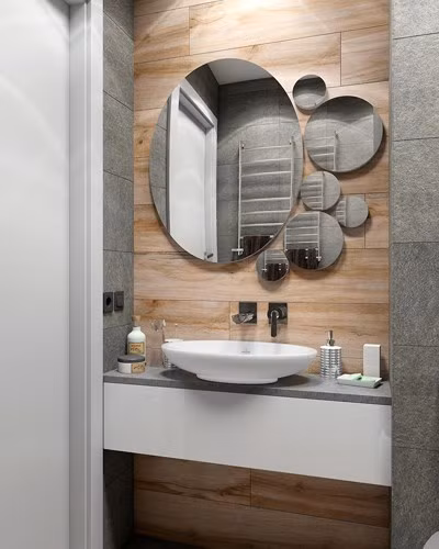 Các yếu tố góc đảm bảo phòng tắm vẫn giữ được tính thẩm mỹ tinh gọn. Bồn rửa tay và gương hình cầu sắp xếp sáng tạo đẩy cao tính thẩm mỹ cho phòng tắm.