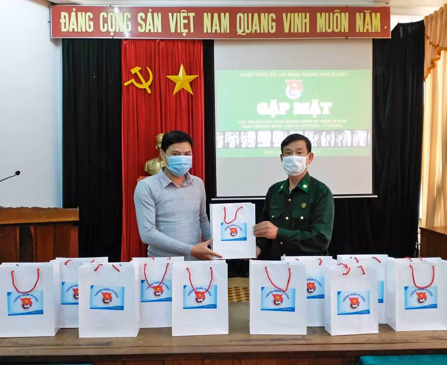 Anh Phan Minh Đức (bìa trái)-Bí thư Thành Đoàn Pleiku tặng quà cho Cựu Thanh niên Xung phong TP.Pleiku.