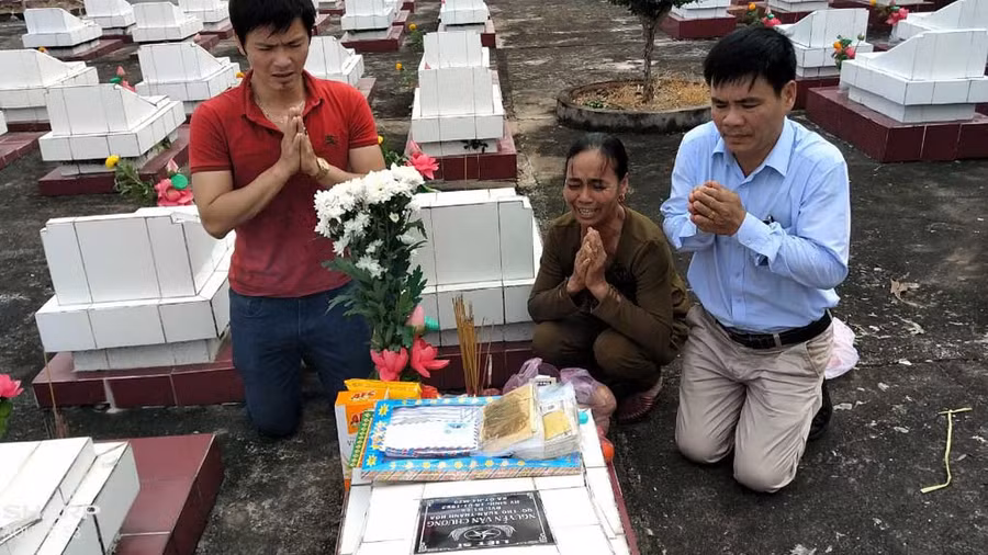 Anh Nguyễn Hùng Văn (bìa phải) tìm được mộ bố nhờ sự giúp đỡ của ông Sỹ Hồ