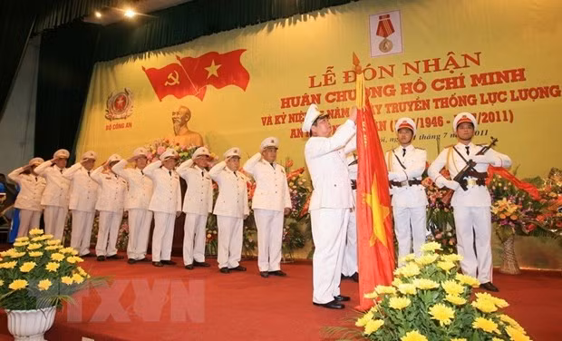 Đại tướng Lê Hồng Anh, Ủy viên Bộ Chính trị, Bộ trưởng Bộ Công an, gắn Huân chương Hồ Chí Minh lên cờ truyền thống của Tổng cục An ninh II tai Lễ kỷ niệm 65 năm Ngày truyền thống lực lượng An ninh nhân dân (12/7/1946-12/7/2011). Ảnh: Thống Nhất-TTXVN