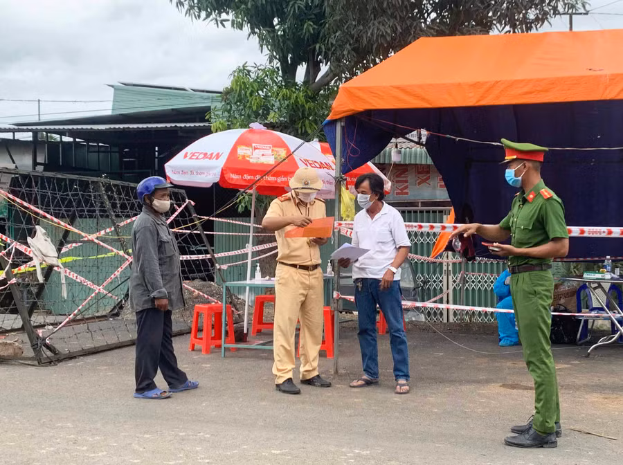 Lực lượng chức năng hướng dẫn người dân các thủ tục cần thiết khi qua chốt kiểm dịch.Ảnh.Vũ Chi