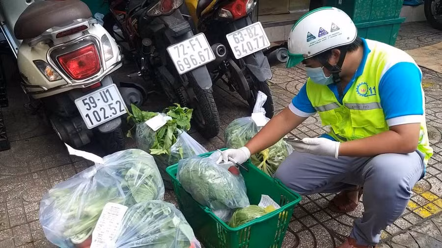 Shipper tình nguyện tại P.10, Q.11 kiểm tra hàng hóa trước khi giao cho người dân. ẢNH: MINH NHỰT