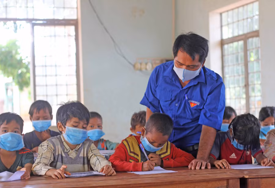 Anh Kpuih Muôn-Bí thư Đoàn xã Ia Kriêng (huyện Đức Cơ) hướng dẫn các em thiếu nhi làng Grôn học bài. Ảnh: Phan Lài