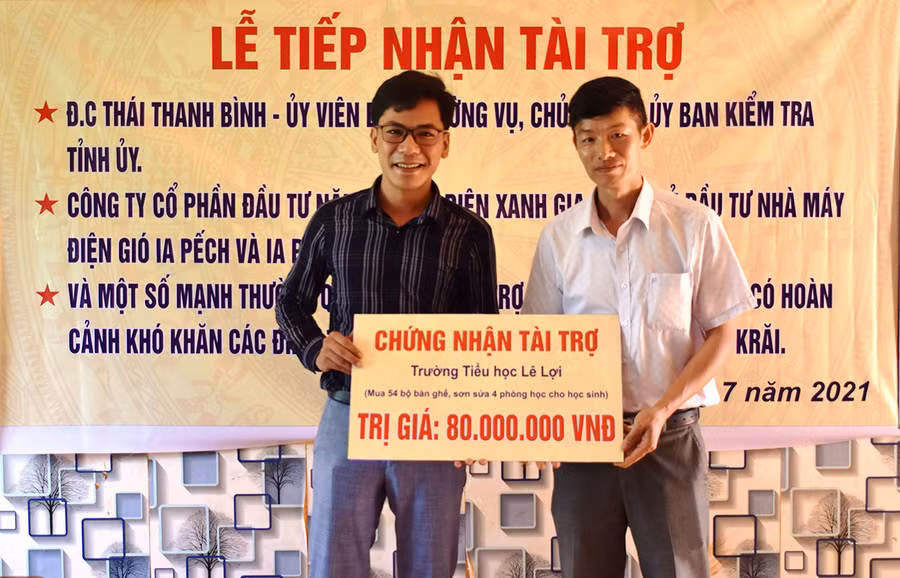 Đại diện Công ty cổ phần Đầu tư Năng lượng Điện xanh Gia Lai trao bảng tài trợ cho nhà trường. Ảnh: Minh Thoan