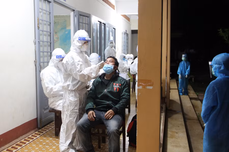 Nhân viên y tế lấy mẫu test nhanh những người trở về từ Đồng Nai. Ảnh: Hoàng Bình