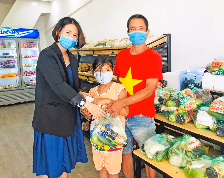 Chị Nguyễn Xuân Quỳnh-chủ cửa hàng Hoa quả Gia Lai tặng quà cho người dân khó khăn. Ảnh: Thủy Bình