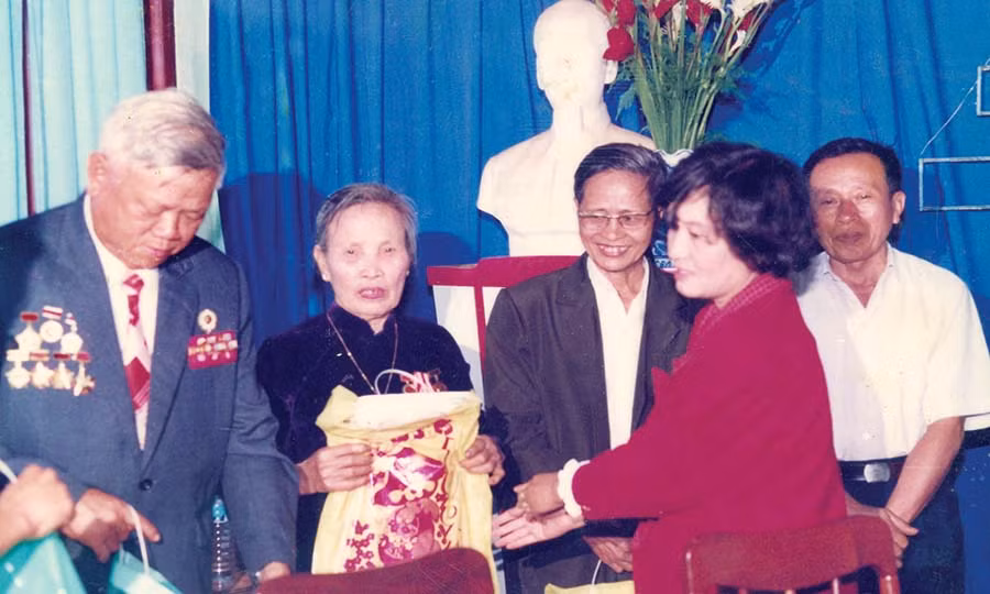 Nhà báo Đặng Thị Thu Hà tặng quà cho các đồng chí lão thành cách mạng. Ảnh: Đ.T
