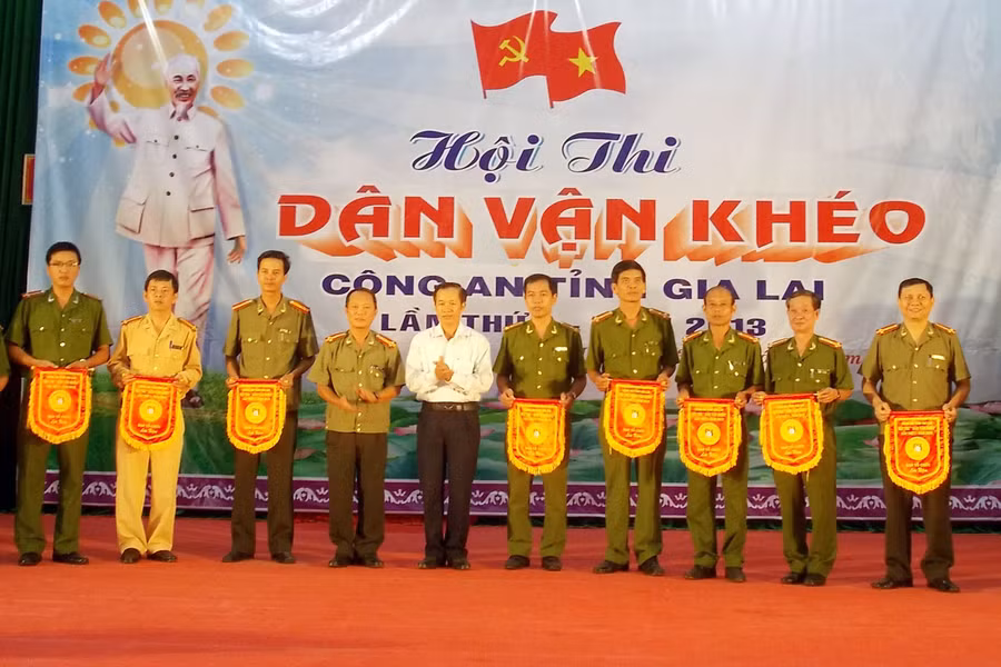 Lãnh đạo Ban Dân vận Tỉnh ủy và Công an tỉnh tặng cờ lưu niệm cho các đội dự thi. Ảnh: Thanh Nhật