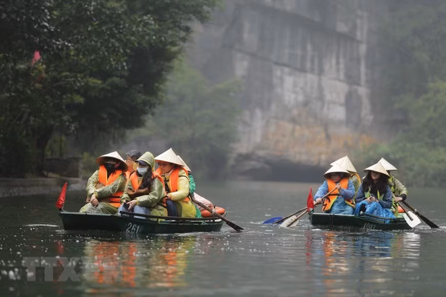  Một trong những trải nghiệm thú vị dành cho du khách khi đến Tràng An chính là ngồi thuyền xuôi dọc theo dòng sông nhìn ngắm cảnh vật xung quanh. (Ảnh: Minh Đức/TTXVN)
