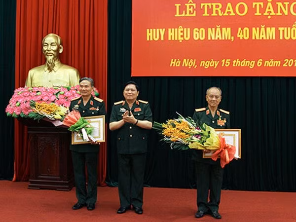 Đại tướng Ngô Xuân Lịch, Bộ trưởng Bộ Quốc phòng trao Huy hiệu 60 năm tuổi Đảng cho Đại tướng Phạm Văn Trà (bên phải); huy hiệu 40 năm tuổi Đảng cho Thượng tướng Trương Quang Khánh (trái).