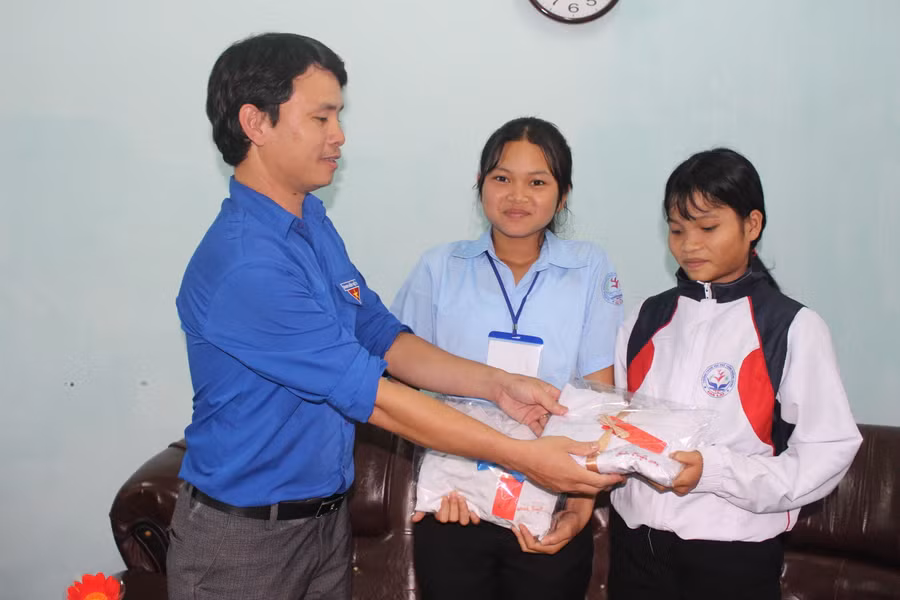  Thầy Phạm Văn Nguyên-Bí thư Đoàn trường THPT Trường Chinh-trao quà của các nhà hảo tâm cho học sinh có hoàn cảnh đặc biệt khó khăn. Ảnh: N.G