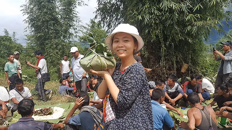 Tác giả Cẩm Tú “dự tiệc” cùng người dân trên đường đến làng Longwa của bộ tộc Konyak. Ảnh: TN