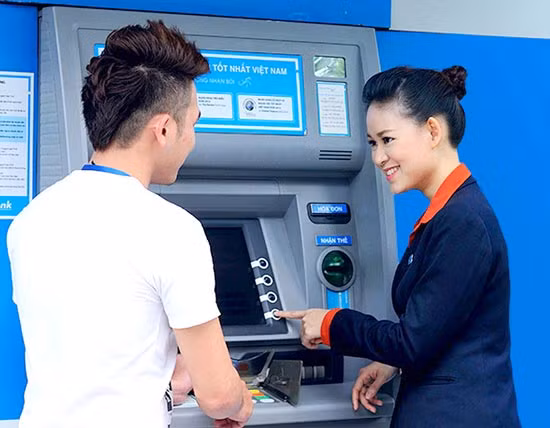 Nhân viên ngân hàng hướng dẫn khách hàng bảo mật trong giao dịch thẻ.