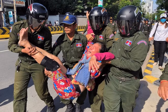  Lực lượng chức năng Campuchia mang một người biểu tình rời khỏi khu vực Đại sứ quán Trung Quốc ngày 23.10.2020 - Ảnh: Reuters