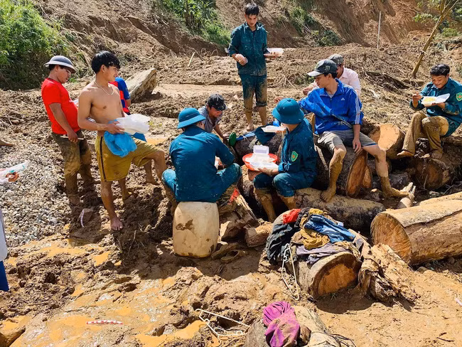 Đoàn thanh niên, dân quân tự vệ xã Phước Lộc ăn vội bữa trưa trên đống đổ nát để tiếp tục tìm 2 cán bộ xã Phước Lộc là Hồ Văn Sợ và Hồ Văn Độ đi cứu hộ bà con thì bị vùi lấp mất tích tại thôn 1, xã Phước Lộc.