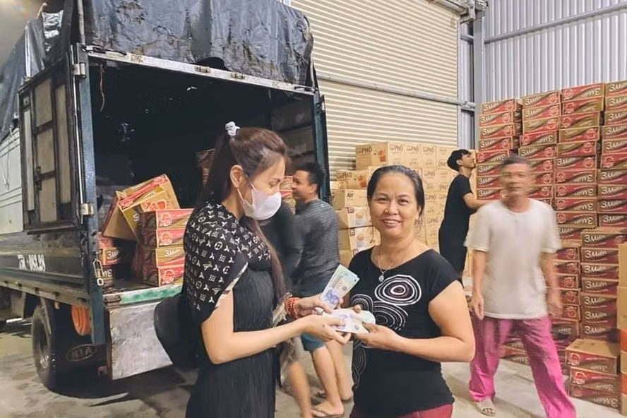 Ca sĩ Thủy Tiên trao quà cho đồng bào vùng ngập lụt.